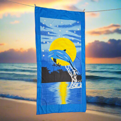 Beach towel with dolphins and sunset design on a blue background