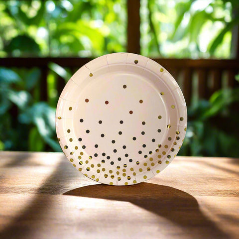 Beige paper plate with gold polka dots on a white background