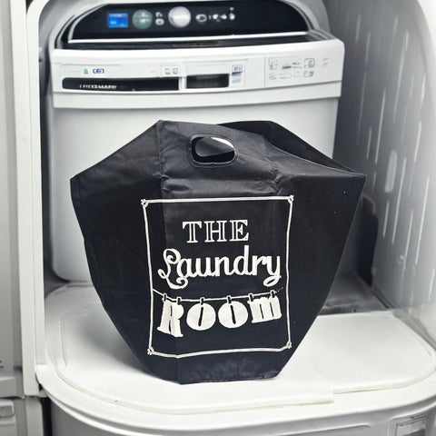 Black laundry bag with 'The Laundry Room' text inside an open dryer.