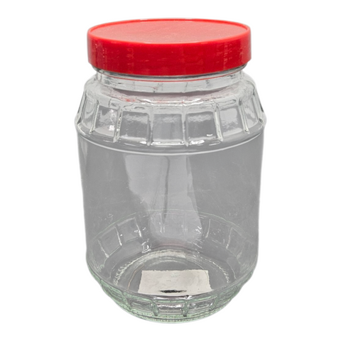 Clear glass jar with a red lid on a white background