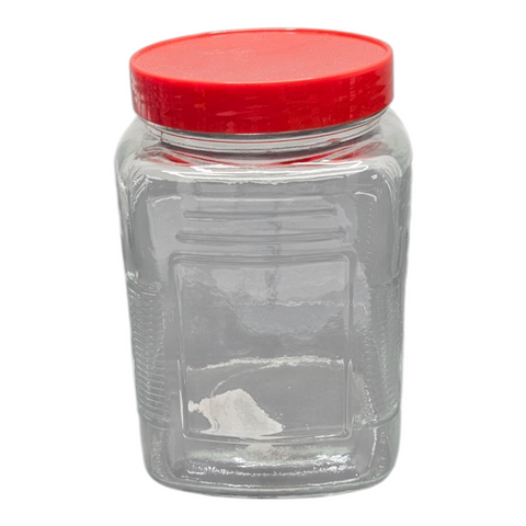 Clear glass jar with a red lid on a white background