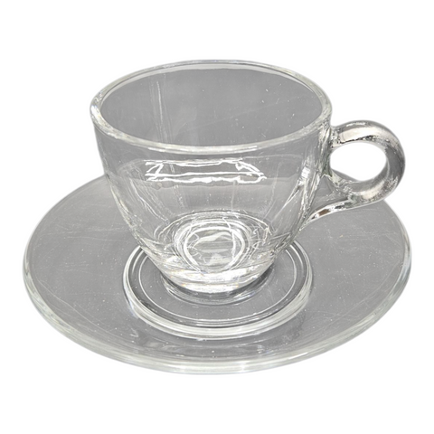 Clear glass teacup and saucer on a white background