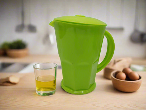 Green plastic pitcher with a lid on a white background