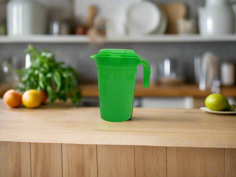 Green plastic pitcher with a lid on a white background