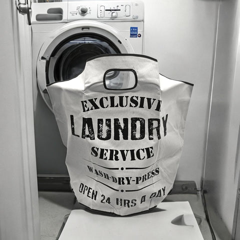 Laundry bag labeled 'Exclusive Laundry Service' in front of a washing machine.