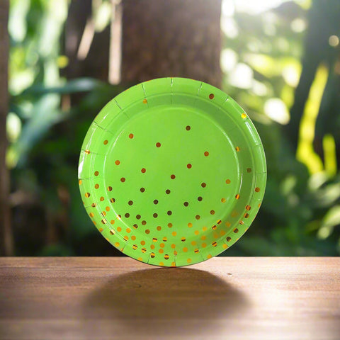 Green paper plate with gold polka dots on a white background