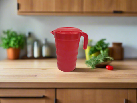 Red plastic pitcher with a lid on a white background