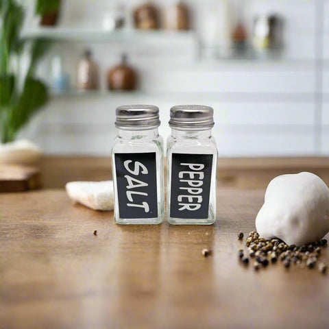Salt and pepper shakers with labeled black tags on a white background