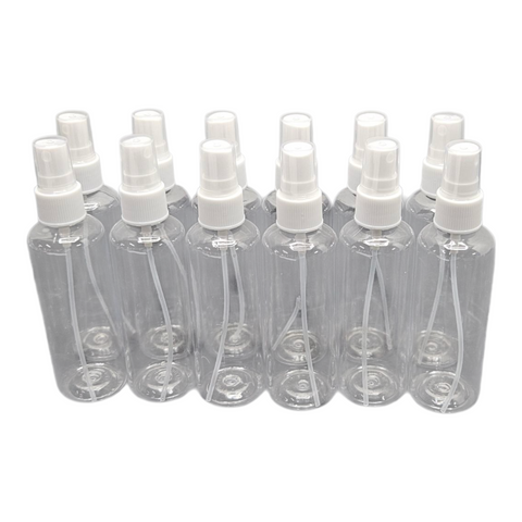 Set of clear spray bottles with white nozzles on a white background