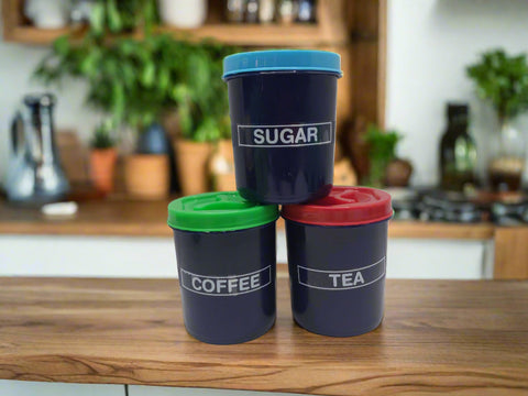 Three navy blue containers with colored lids labeled 'Sugar', 'Coffee', and 'Tea' on a white background.