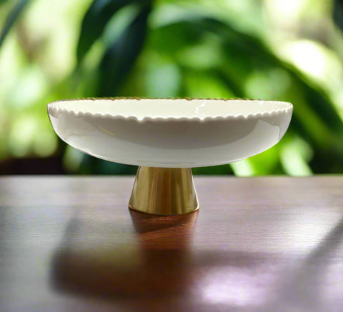 White ceramic bowl with gold base on a white background