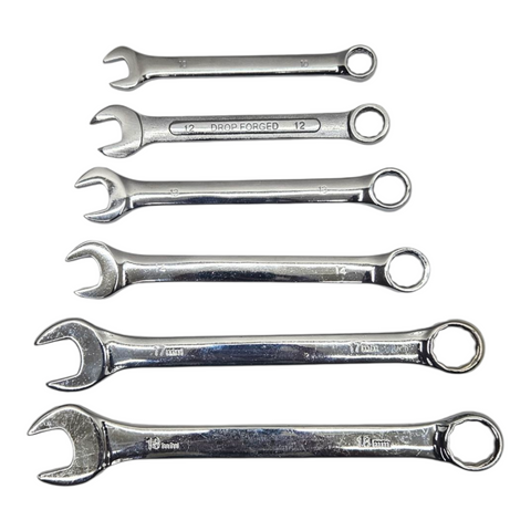 Set of six metallic wrenches on a white background