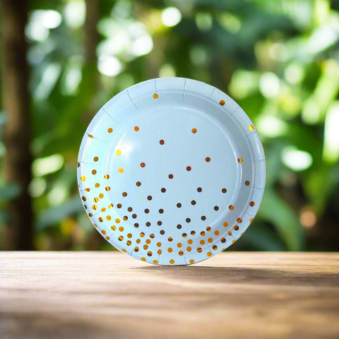 Light blue paper plate with gold polka dots on a white background
