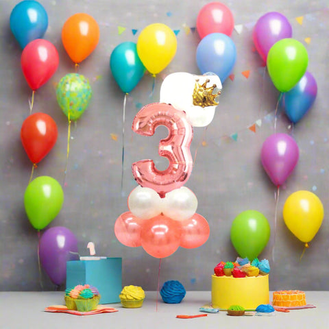 Pink number '3' balloon with a crown and small balloons on a white background